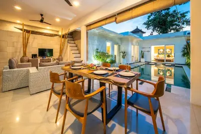 a kitchen and living room with a table and chairs at Villa Khanphi Seminyak in Seminyak
