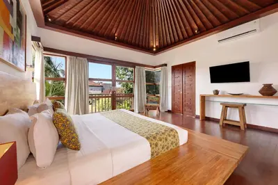 a bedroom with a large bed and a television at Villa Amira 5BR Villa 17m Pool Near Legian Beach in Legian