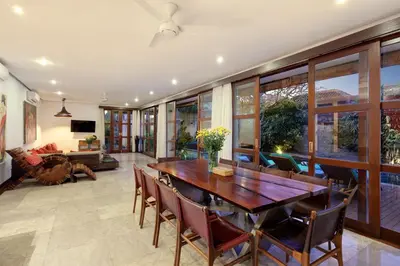 a dining room with a wooden table and chairs at Villa Amira 5BR Villa 17m Pool Near Legian Beach in Legian
