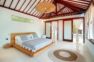 a bedroom with a bed in a room with windows at Lepa Villa, Oasis in Legian in Seminyak