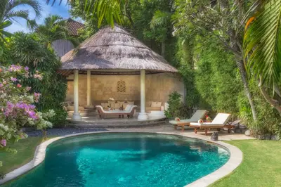 a swimming pool in a yard with a gazebo at Villa Kubu Seminyak in Seminyak