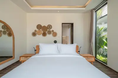 a bedroom with a white bed and a large window at Villa Selikur 1 - Spacious 3BR Villa in Seminyak! Perfect location! in Seminyak