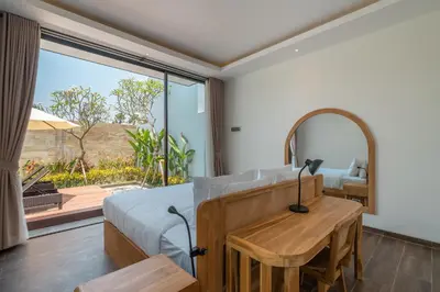 a bedroom with a bed and a table and a mirror at Villa Selikur 1 - Spacious 3BR Villa in Seminyak! Perfect location! in Seminyak