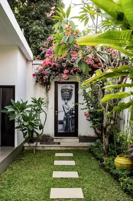a garden with a picture of a statue in front of a building at Villa Jami by BaliSuperHost in Seminyak