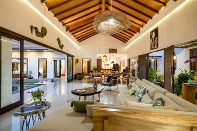an open living room with a couch and tables at Villa Jami by BaliSuperHost in Seminyak