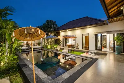 a house with a swimming pool and an umbrella at Villa Jami by BaliSuperHost in Seminyak