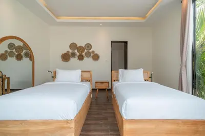 two beds in a room with a window at Villa Selikur 2 - Brand New! Spacious 3BR Villa in Seminyak in Seminyak