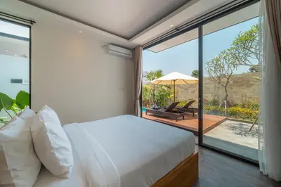 a bedroom with a bed and a balcony with an umbrella at Villa Selikur 2 - Brand New! Spacious 3BR Villa in Seminyak in Seminyak