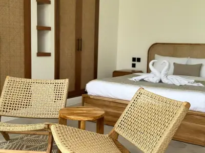 a bedroom with a bed with wicker chairs and a bedvisor at Villa Solaris Umalas by Santi Management in Kerobokan