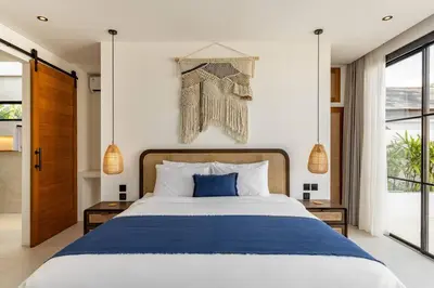 a bedroom with a large bed with a blue blanket at Villa Anita Umalas by Santi Management in Kerobokan