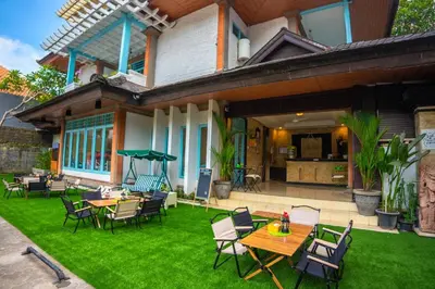a patio with tables and chairs in front of a house at BS Home in Kuta