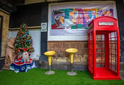 a christmas tree and a red phone booth in front of a house at BS Home in Kuta