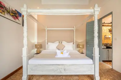 a bedroom with a white canopy bed with two pillows at Villa Vaiana Seminyak in Seminyak