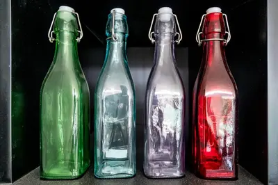 four glass bottles are lined up in a row at Villa KALOOKA, a vacation in paradise. in Seminyak