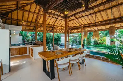 a kitchen and dining room with a wooden table and chairs at Villa Marula at Bidadari in Seminyak