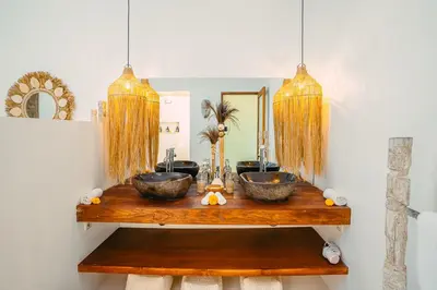a bathroom with two bowls on a wooden table at Villa Marula at Bidadari in Seminyak