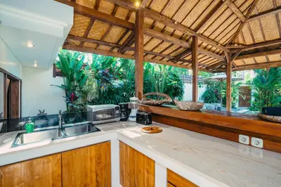 a kitchen with a sink and a large window at Villa Marula at Bidadari in Seminyak