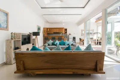 a living room with a large couch with blue pillows at Stylish Three Bedroom Villa Near Atlas Beach Club & Beach. in Canggu