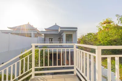 a house with a white railing on a balcony at Villa Rose 1 Sanur in Sanur