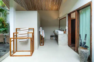 a bathroom with a sink and a mirror at The Gardens Seminyak in Seminyak