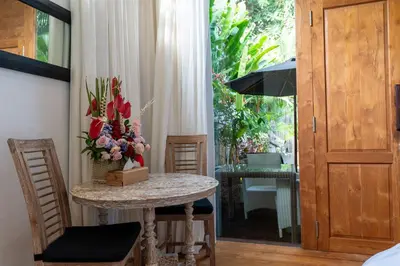 a room with a table with a vase of flowers at The Gardens Seminyak in Seminyak