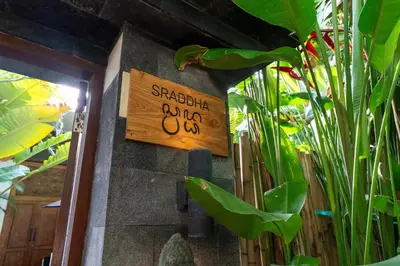 a sign on the side of a wall with plants at The Gardens Seminyak in Seminyak