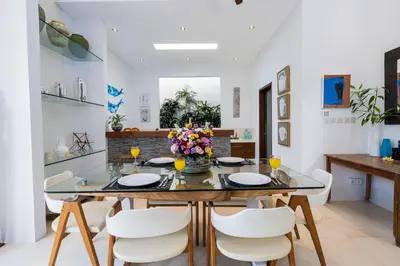 a dining room with a glass table and white chairs at Villa Celine 2 chambres piscine Seminyak BALI in Seminyak