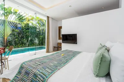a bedroom with a bed and a swimming pool at Villa Celine 2 chambres piscine Seminyak BALI in Seminyak