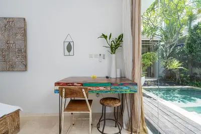 a home office with a table and a swimming pool at Villa Celine 2 chambres piscine Seminyak BALI in Seminyak