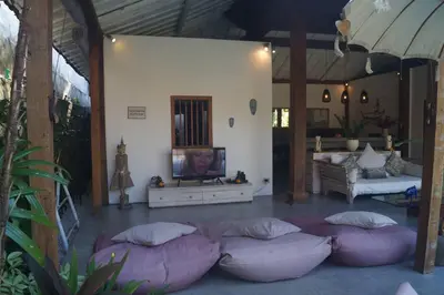 a living room with purple pillows and a tv at Villa Joglo Oberoi Seminyak Beautiful 4BR Villa Prime Location in Seminyak