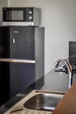 a kitchen with a sink and a microwave at Villa Mana Tea 2 bedrooms & pool Seminyak in Seminyak