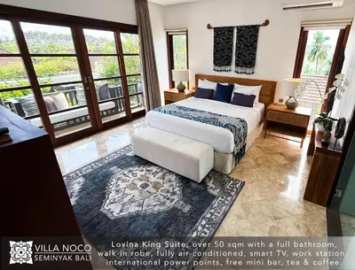 a bedroom with a bed and a large window at Noco Luxury Villa Seminyak in Seminyak