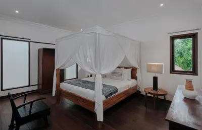 a bedroom with a bed with a canopy at Nativ Living Villa Legian 6BR Villa 16px Big Group Walk to 66 Beach in Seminyak
