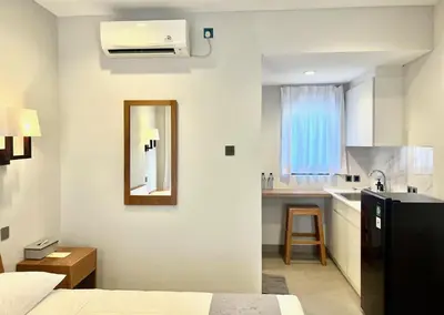 a bedroom with a bed and a sink and a mirror at Charlie Guest House in Nusa Dua