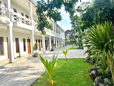 a courtyard of a building with trees and plants at Charlie Guest House in Nusa Dua