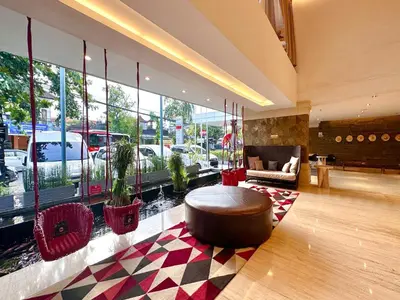 a lobby with a coffee table in front of a large window at Grand Zuri Kuta Bali in Kuta