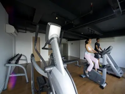 two people exercising on tread machines in a gym at Grand Zuri Kuta Bali in Kuta