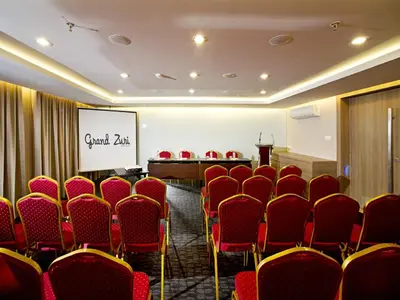 a conference room with red chairs and a screen at Grand Zuri Kuta Bali in Kuta