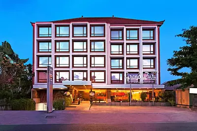 a large building with a sign in front of it at Grand Zuri Kuta Bali in Kuta