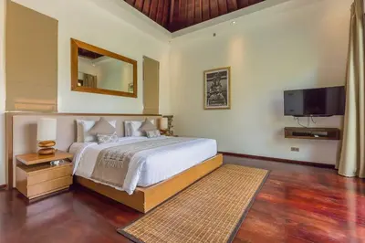 a bedroom with a large bed and a television at Eshara 3 our Peaceful 3BR Pool Villa close to Oberoi Beach in Seminyak