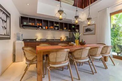 a dining room with a wooden table and chairs at Eshara 3 our Peaceful 3BR Pool Villa close to Oberoi Beach in Seminyak