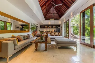 a living room with a couch and a table at Eshara 23 an Amazing 5 BR Pool Villa walking distance to Beach in Seminyak