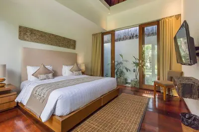a bedroom with a large bed and a large window at Eshara 23 an Amazing 5 BR Pool Villa walking distance to Beach in Seminyak