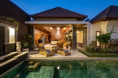 a backyard with a swimming pool and a house at Villa Lapiz in Seminyak