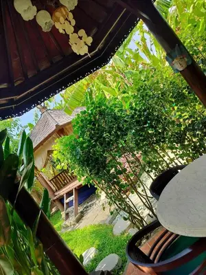 a view of a garden with a house in the background at Villa Layang Bulan a homey guesthouse for men near the beach in North Kuta in Denpasar