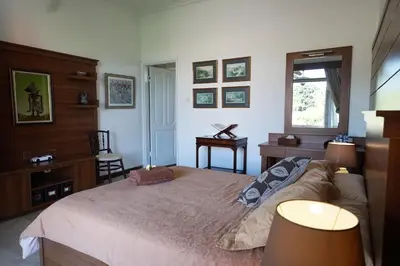 a bedroom with a bed and a desk and a window at Guildwood Villa Bali in Sanur