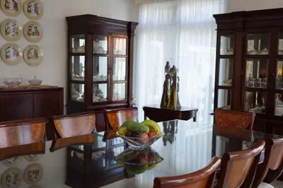 a dining room with a bowl of fruit on a glass table at Guildwood Villa Bali in Sanur