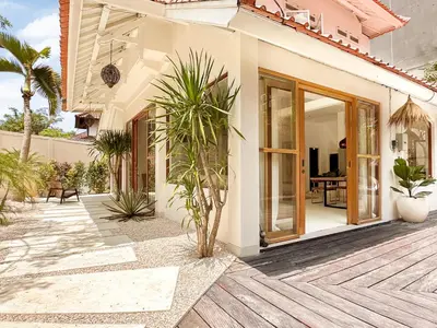 a house with a courtyard with palm trees at Stylish 2bdr poolvilla Centre Seminyak in Seminyak