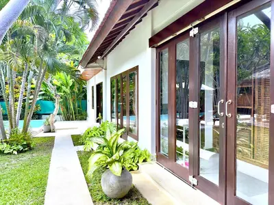 a house with a courtyard with plants in front of it at An Amazing 6BDR Private Family Villa with Pool in Tanah Lot