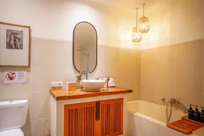 a bathroom with a sink and a toilet and a mirror at An Amazing 6BDR Private Family Villa with Pool in Tanah Lot